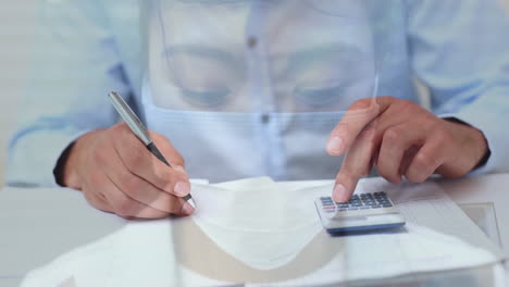 el papeleo y la calculadora sobre la mujer con la máscara.