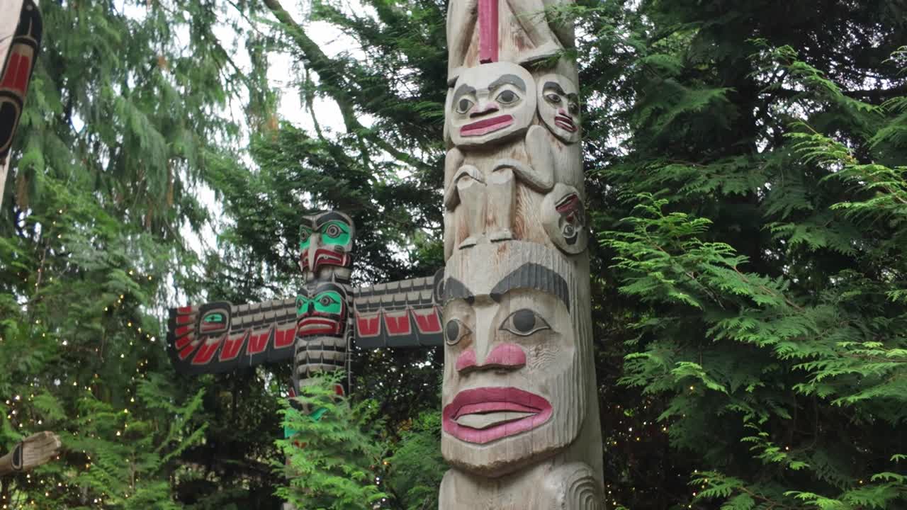 Panoramica ravvicinata stabilizzata su pali totemici delle Prime Nazioni al Capilano Suspension Bridge Park a North Vancouver, British Columbia, Canada. 4K a 30 FPS