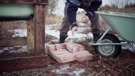 The-Man-is-Removing-Bricks-From-the-Wheelbarrow-to-Utilize-them-for-the-DIY-Hot-Tub---Static-Shot