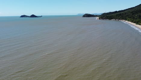 4k drone shot of a sandy beach and a small island in north queensland, australia