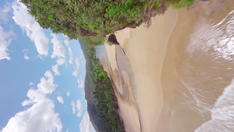 - volando verticalmente sobre una playa tropical hacia río san juan en samaná, república dominicana