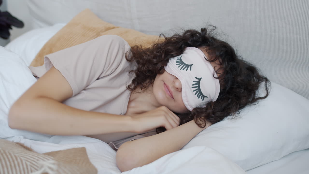 mujer durmiendo en la cama con una máscara para dormir