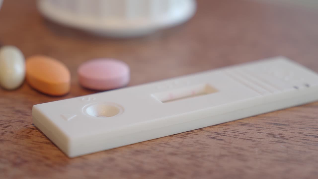 テーブルの上の妊娠検査薬と錠剤
