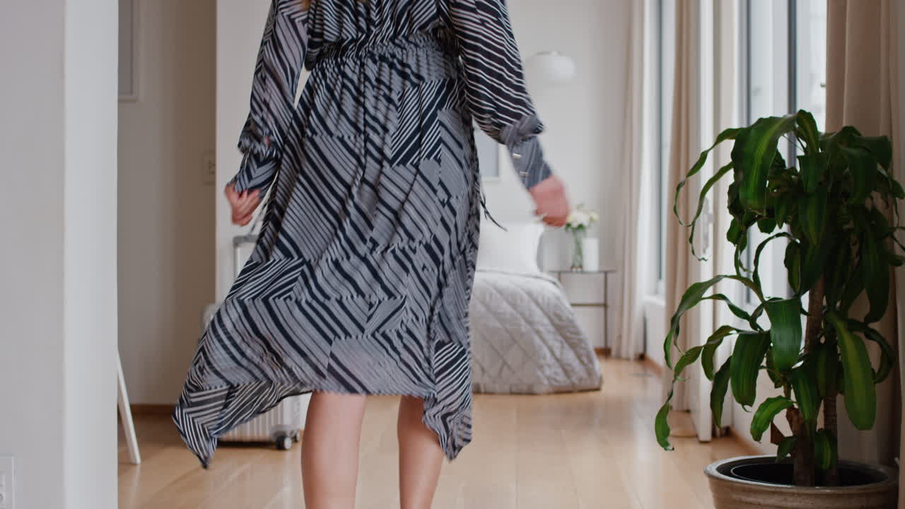 행복한 여성이 호텔 방에서 침대에 뛰어들고 즐거움을 즐기고 휴가 생활 방식을 즐기고 자유를 축하하고 있습니다.