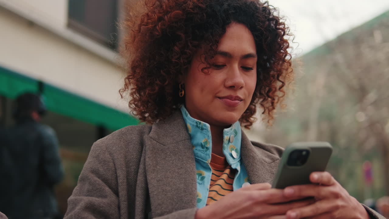 Woman Using Phone on City Street