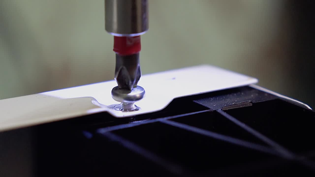 4 개의 가구를 제조하는 마스터는 스크루드라이버를 사용하여 식기 세척기를 클로즈업 슬로우 모션으로 설정합니다.