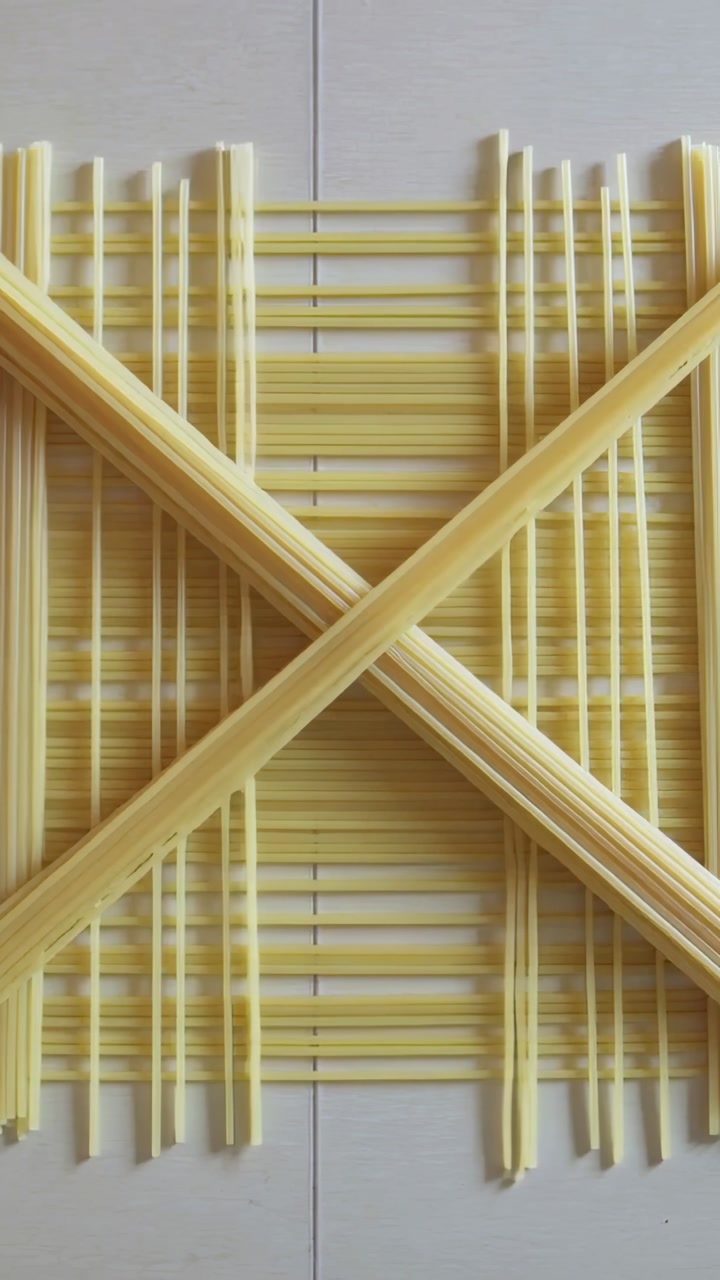 Vertical video: Adding diagonal pasta bundles and sticks from base, forming lattice on sheet, seam