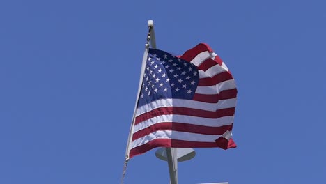 Slow-motion-shot-of-an-American-Flag-with-a-perfect-blue-sky-as-a-background