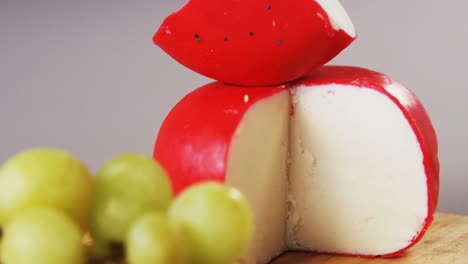 red cheese and grapes on wooden board