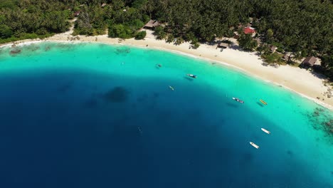 Aerial-view-of-amazing-tropical-island-with-palm-trees-and-bungalows-in-Indonesia