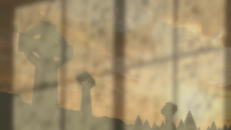 silhouetted celtic crosses and trees seen through foggy window during sunset animation