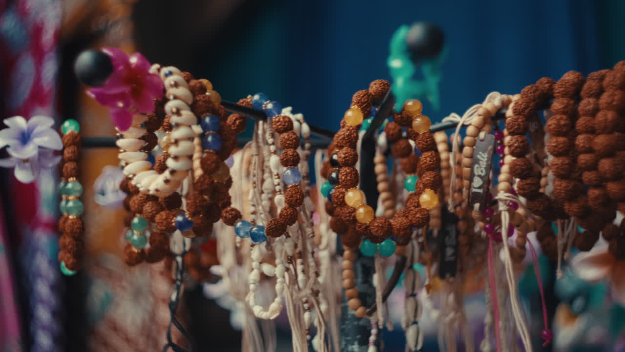 A vibrant close-up shot of artisanal bracelets featuring Rudraksha seeds and colorful beads, displayed at a local market in the Ubud Monkey Forest area, Bali