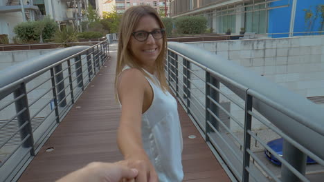 chica sosteniendo la mano de su novio y sonriendo a la cámara