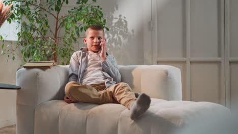 niño sonríe escuchando a un amigo hablando por teléfono después de la escuela