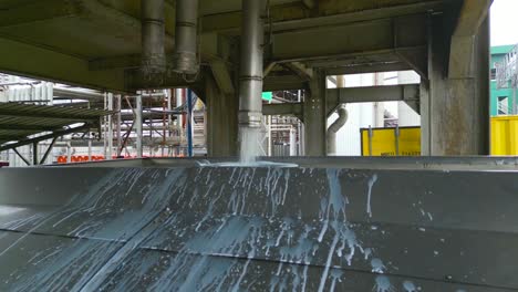 close up of filling kernel palm oil in a truck through metal pipe at factory, malaysia