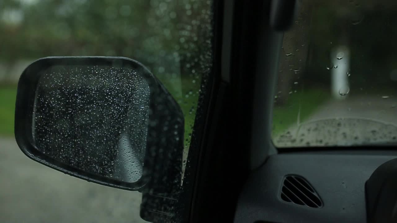 폭풍우 동안 빗방울이 있는 자동차의 사이드 미러
