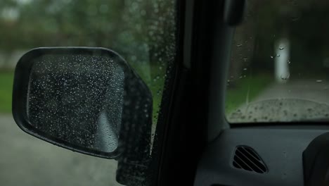 side mirror of a car with rain droplets during storm