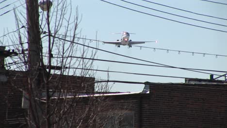 Un-Avión-De-Vuelo-Bajo-Pasa-Sobre-Líneas-Eléctricas-Y-El-Centro-De-La-Ciudad