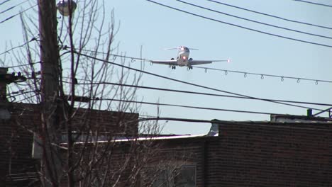 a lowflying airplane passes over power lines and the inner city