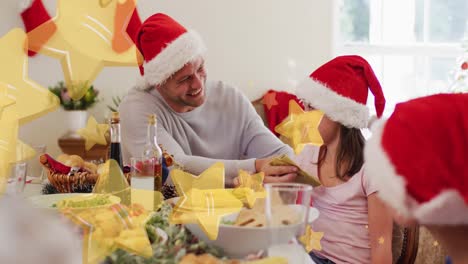 Yellow-star-falling-against-caucasian-father-wiping-face-of-his-daughter-during-christmas