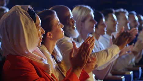 business people applauding while sitting on seats in auditorium 4k