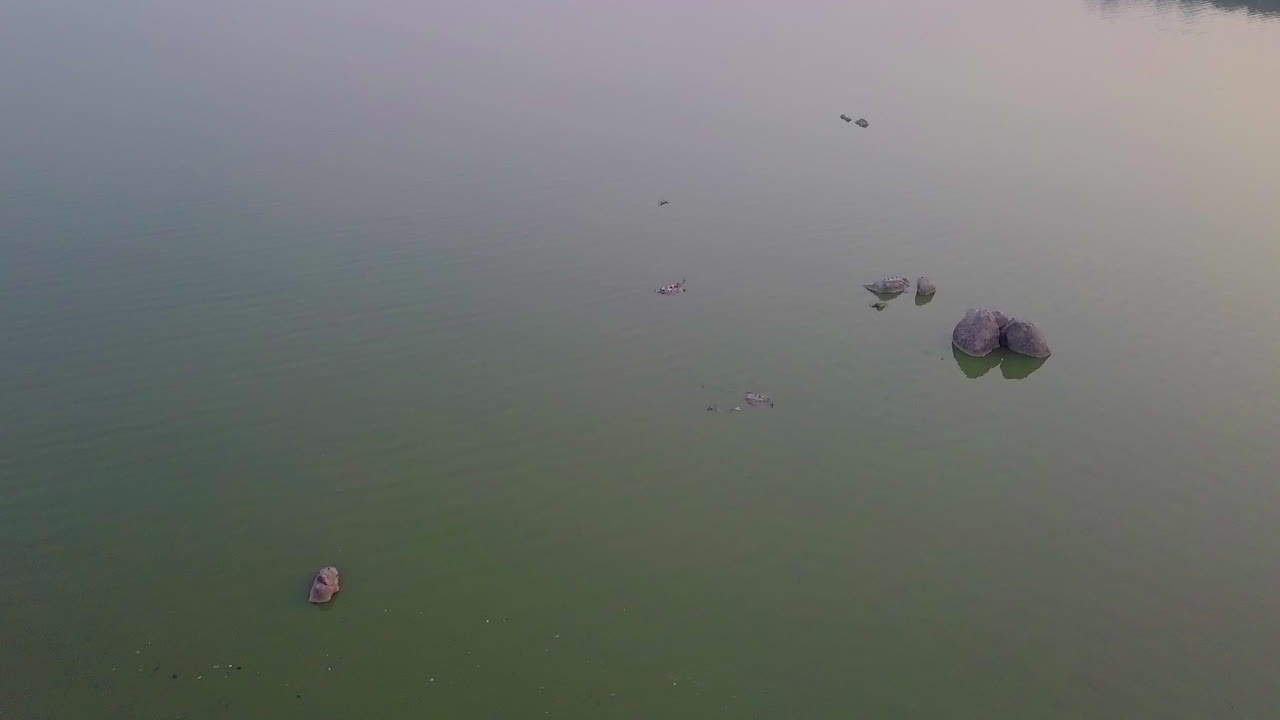 Top view of a resort with swimming pool and revealing cityscape of Hyderabad during sunset in India. Drone shot.