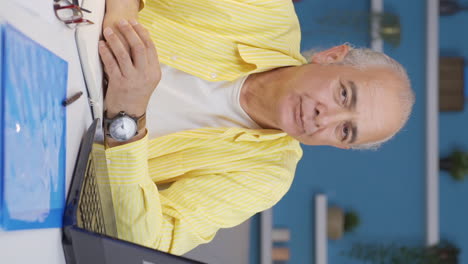 vertical video of home office worker old man nods to the camera, says no, no.