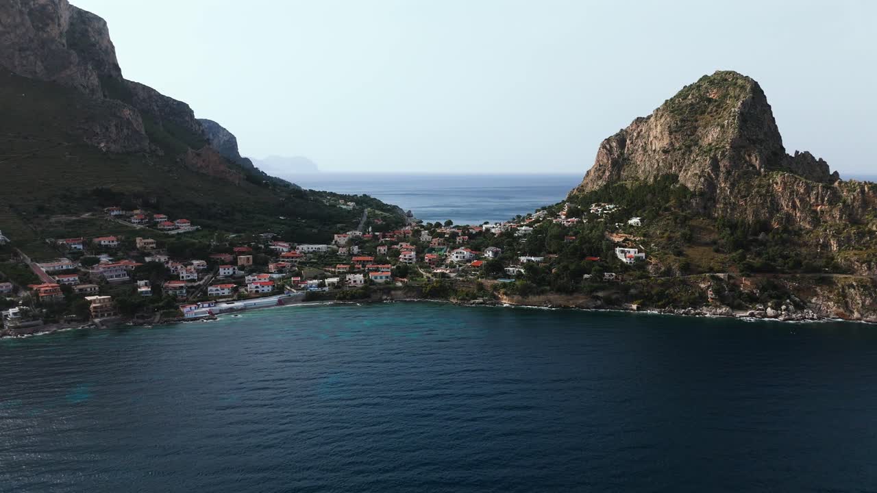 Slow motion 4K drone footage of Sant Elia village and Capo Zafferano in Sicily Italy showing colorful hillside homes steep cliffs and deep blue Tyrrhenian Sea with dramatic coastline and clear water