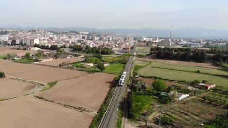 aerial: catalan town in lleida province with a little train departing