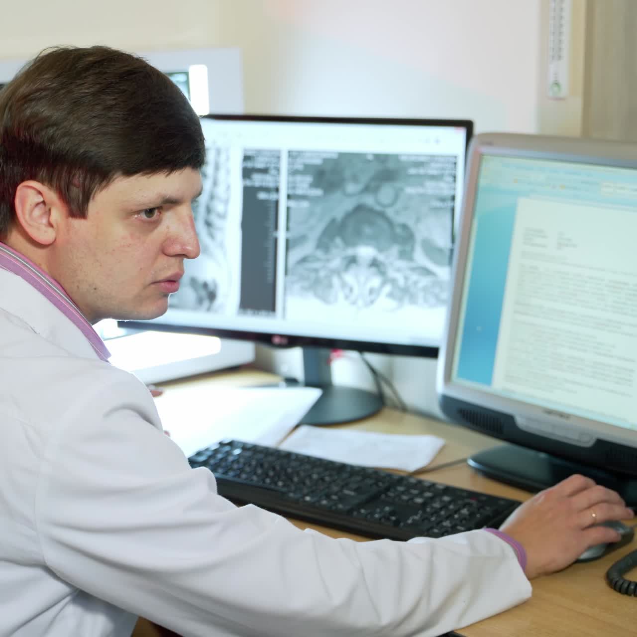 Doctor looking at computer screen. Rear view of doctor in modern hospital looking at computer