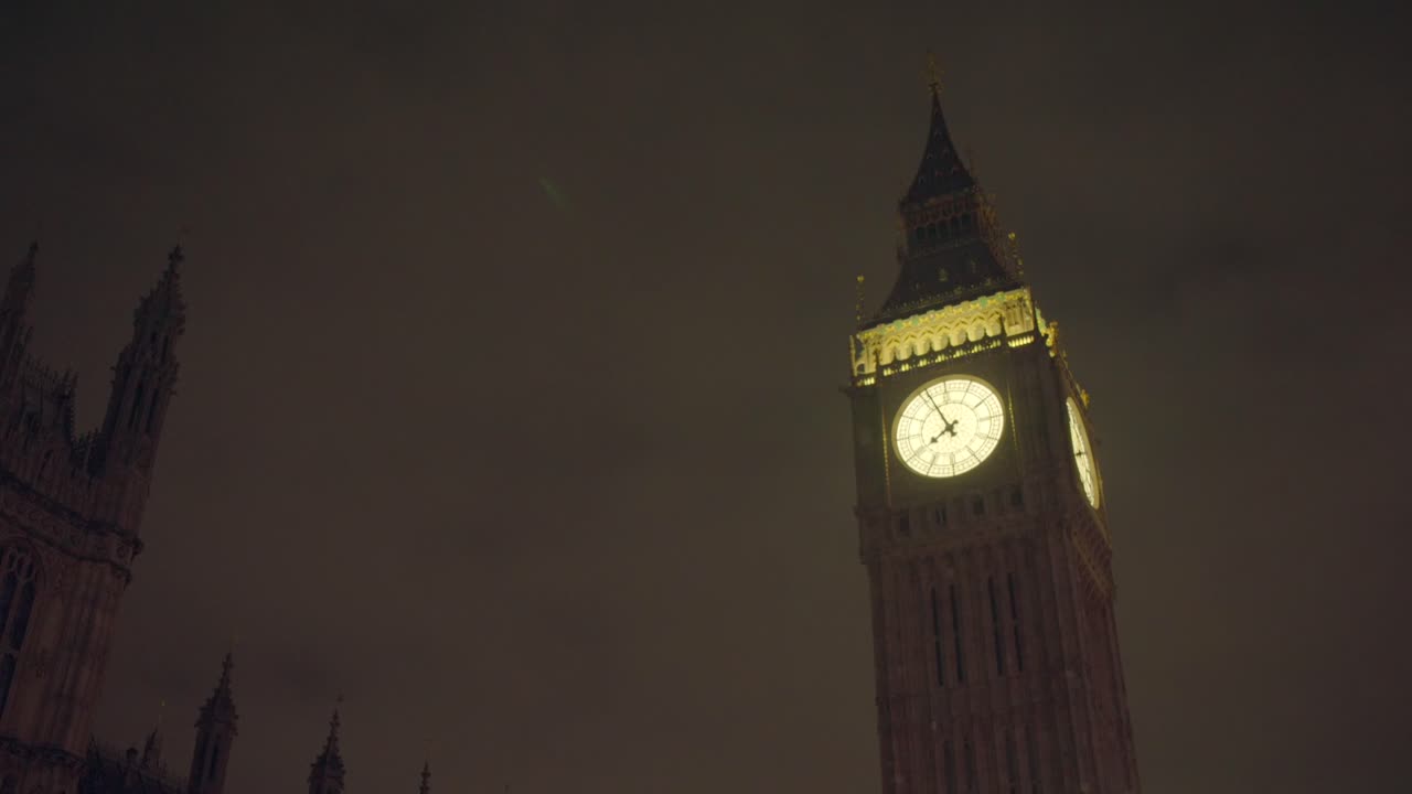 Big Ben Clock in Westminster, London in the United Kingdom. The camera shows the clock face lit up at night. Produced in 4K, 50 frames per second and in REC709 Color Space.