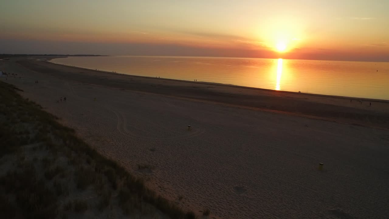 antena: la playa alrededor de la barrera de mareas de tormenta de oosterschelde durante una puesta de sol de verano