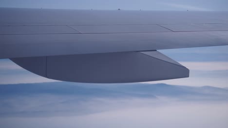 airplane wing over clouds