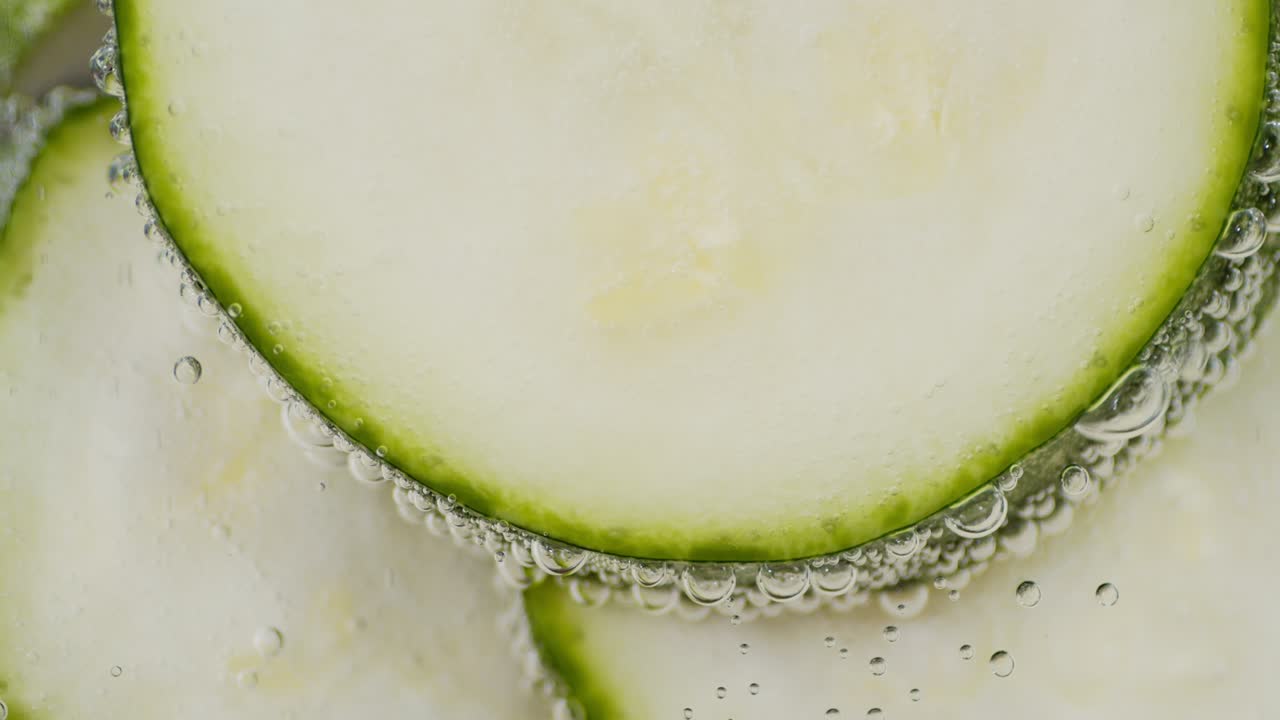 공기 거품으로 물에 담긴 zucchini 조각.