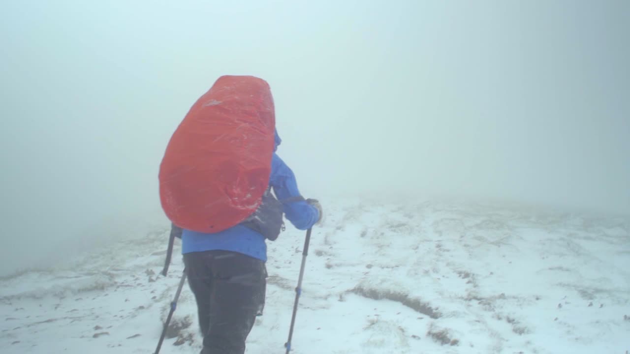 슬로바키아 타트라 산맥의 풍경, 눈 폭풍 속에서 산책하는 여성 하이커를 따라 서서히 촬영된 드