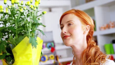 Female-florist-looking-at-bunch-of-flowers