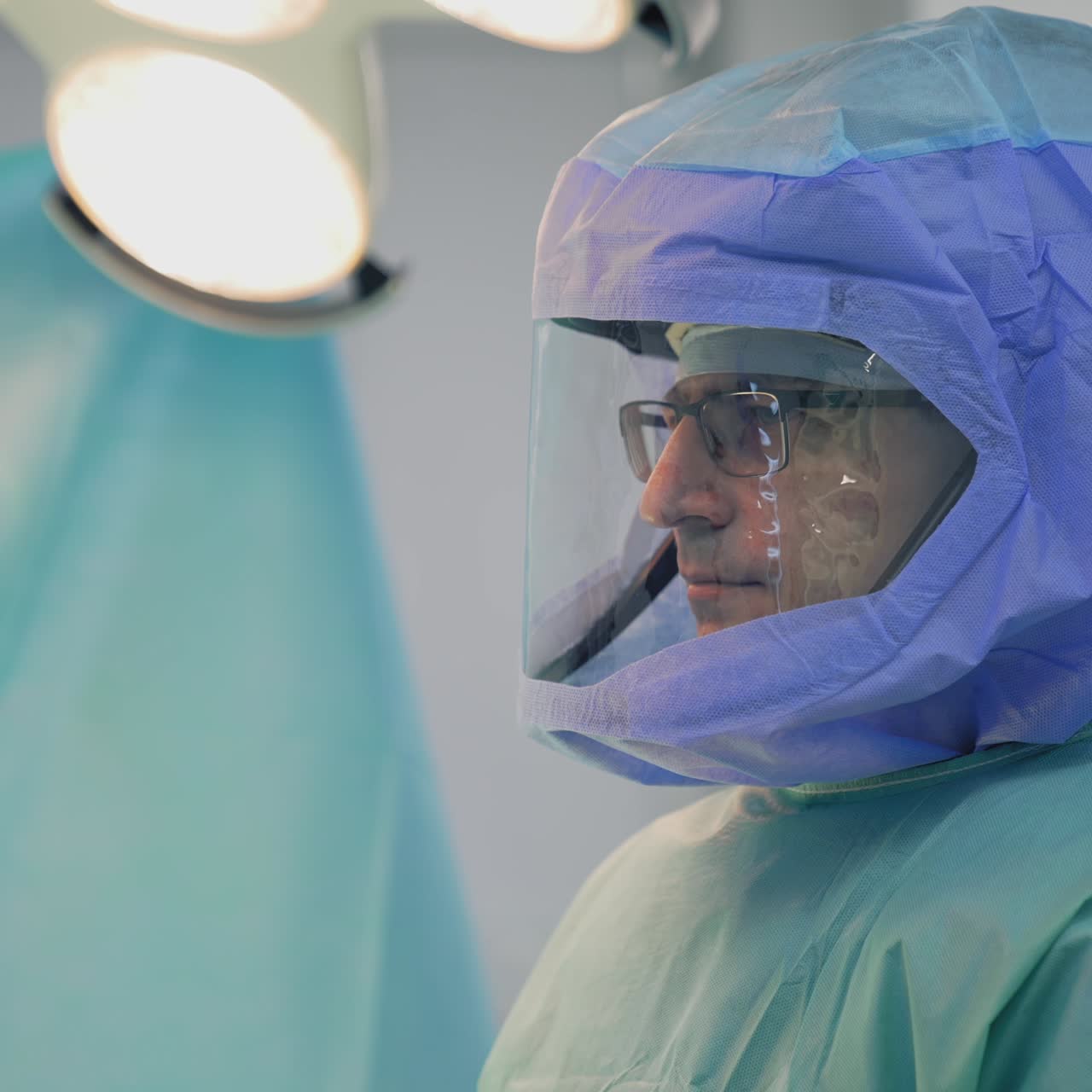 Medical worker in protective cap during pandemic. Portrait of a doctor in safety suit in hospital. Profile view. Protection from coronavirus