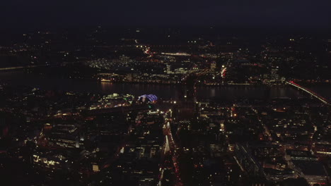 AERIAL:-Beautiful-Wide-Shot-over-Cologne-Germany-at-Night-time-with-City-lights