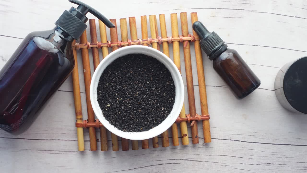 Cumino nero in un contenitore e olio sul tavolo