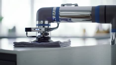 a high-tech robotic arm engaging in precision cleaning with an automated cloth on a surface, showcasing advanced automation in household tasks