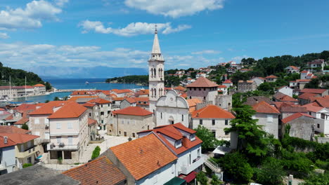 medieval town with the view of saint mary church tower in jelsa, hvar island, croatia. aerial drone shot