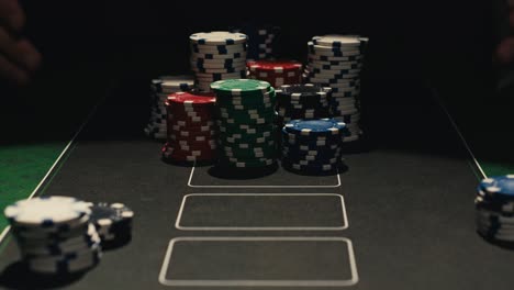 hands managing poker chips on green table, reflecting intense poker gameplay with the element of chance and skill