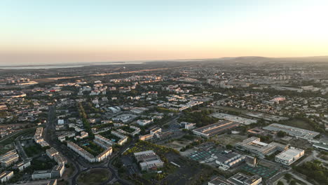 Sunset-casts-a-warm-glow-over-Montpellier's-modern-quarter,-where-the-train-stat