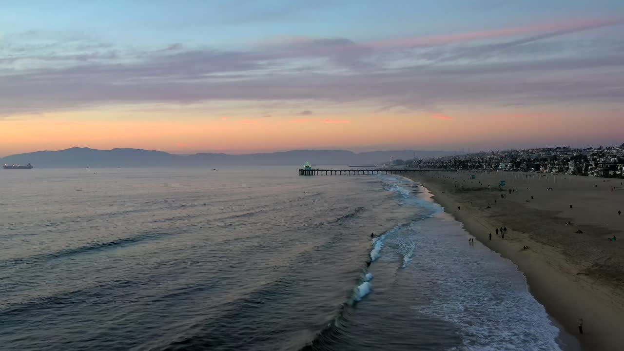 해질녘에 해안에 관광객들이 있는 맨해튼 해변의 고요한 풍경 - 공중 드론 샷