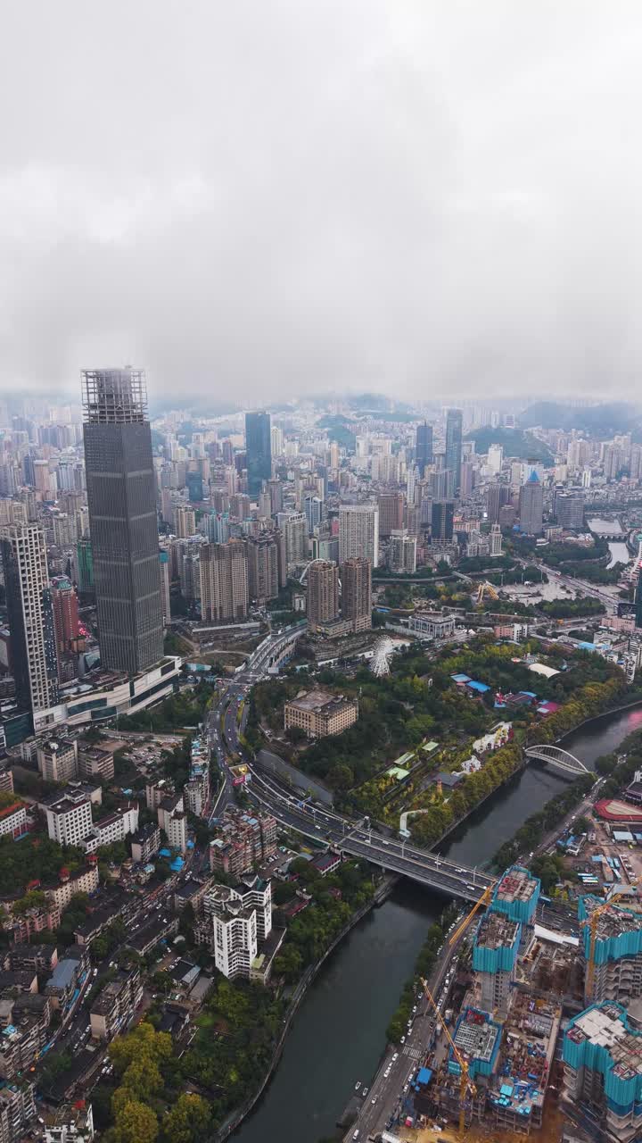 Vertical revealing drone shot of Guiyang’s dense urban layout in Guizhou Province. China