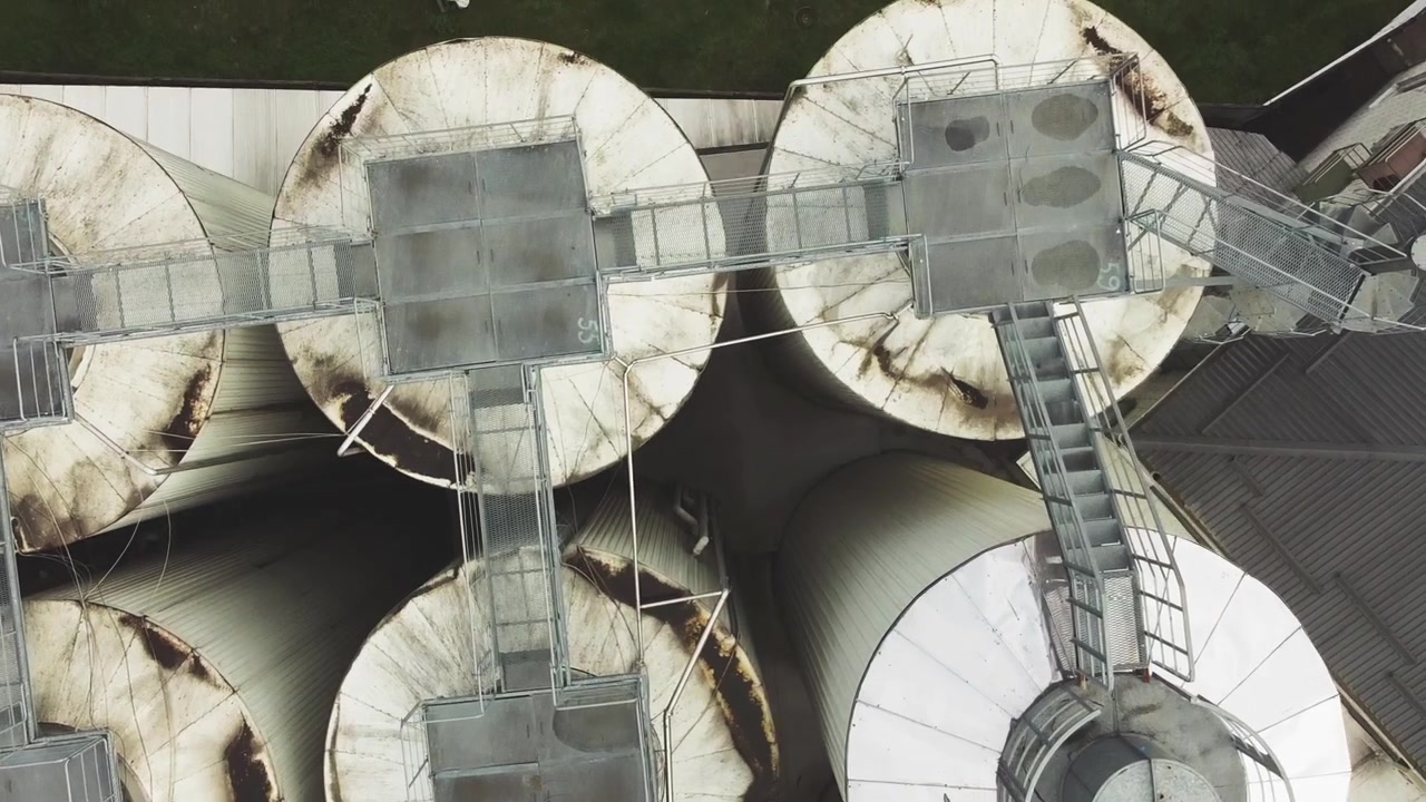Aerial view of a drone flying over the beer production plant, several rows of tanks.