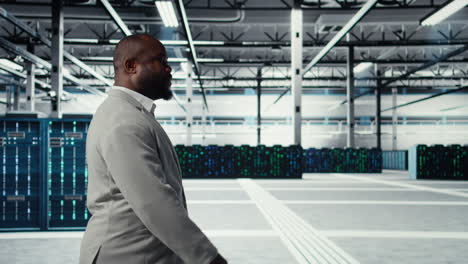 vertical video engineer walking in data center facility, doing inspection on hardware tech