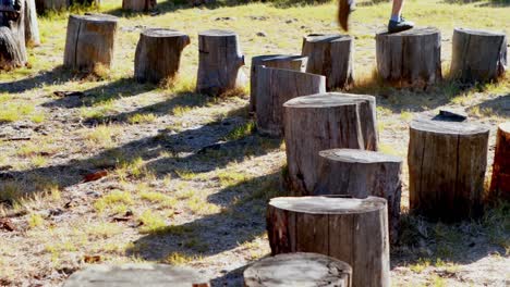 Low-section-of-man-walking-on-tree-stump-4k