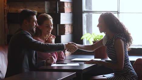 satisfied smiling clients making agreement with mixed race professional.