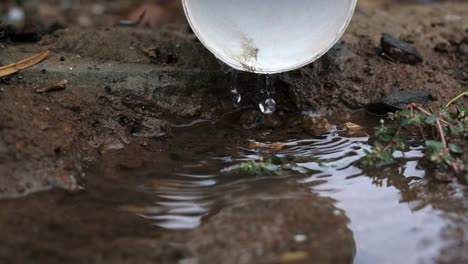 Rain-water-slowly-running-from-a-down-pipe,-slow-motion-and-close-up